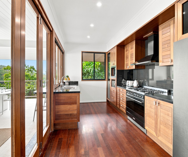 The Boat House, Hamilton Island — bespoke timber kitchen joinery with dark stone benchtops